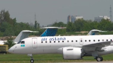 ALMATY, KAZAKHSTAN - 10 Mayıs 2024: Embraer uçağı, Almaty havaalanında taksicilik yapan Air Astana 'lı EI-KHE. Yolcu uçağı havaalanında.