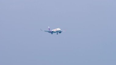 PHUKET, THAILAND - 28 HAZİRAN 2023: Jet uçağı Airbus A320, HK ekspres B-LCO Phuket havaalanına iniş yapıyor, yan görüş. Uçak iniyor. Uçan uçaklar