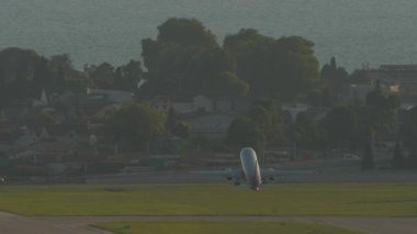 Tanımlanamayan bir kalkış, tırmanma, uzak çekim, dikiz manzaralı yolcu uçağı.