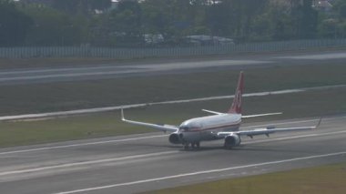 PHUKET, THAILAND - 19 Şubat 2023: Malezya Havayolları 'nın Boeing 737 yolcu uçağı Phuket havaalanına iniş ve fren yapıyor. Spoiler verin. Beneklenme.