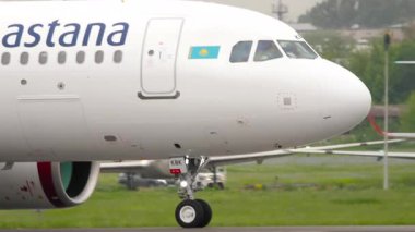 ALMATY, KAZAKHSTAN - 11 Mayıs 2024: Atış, Airbus A320, Air Astana havaalanında taksicilik yapan EI-KBK. Havaalanında yolcu uçağı var. Seyahat konsepti. Beneklenme