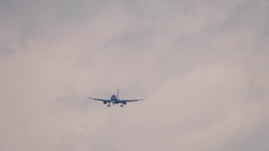 İniş için yaklaşan bir uçak var. Uçan bir jet uçağının görüntüsü. Gökyüzünde uçak silueti. Seyahat kavramı