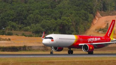 PHUKET, THAILAND - 14 Şubat 2025: Sinematik çekim, Airbus A321, VN-A545 VietJet Air kalkış, yan görüş. Yolcu uçağı kalkıyor. Seyahat kavramı