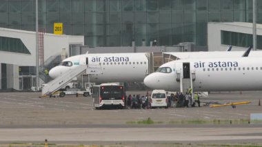 ALMATY, KAZAKHSTAN - 11 Mayıs 2024: Air Astana uçuş yolcuları. Otobüstekiler uçağa biniyor.