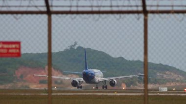 Tanınmaz halde olan ticari jet uçağı hız kazanıyor ve kalkıyor.