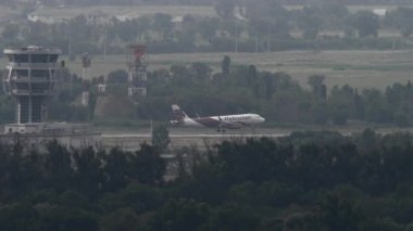 ALMATY, KAZAKHSTAN - 26 Haziran 2024: yan görüş, Airbus A320 Air Arystan iniş uçağı, piste iniyor ve Almaty havaalanında fren yapıyor. Uçak geliyor. Beneklenme