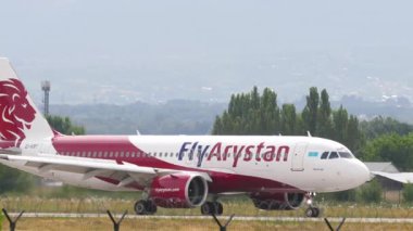 ALMATY, KAZAKHSTAN - 24 Haziran 2024: FlyArystan havaalanında taksicilik yapan Airbus A320. Uçak indikten sonra iniyor. Uçak pistte, yan görüş