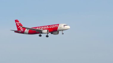PHUKET, THAILAND - 12 Şubat 2023: Lowcoster Airbus A320, AirAsia HS-BBW Mai Khao plajına indi. Uçak iniyor. Seyahat konsepti. Beneklenme