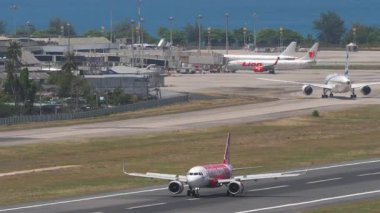 PHUKET, THAILAND - 12 Mart 2025: Airbus A320, Tayland AirAsia 'nın HS-CBF' si Phuket havaalanına indikten sonra fren yapıyor. Yolcu uçağı geliyor. Spoiler hazır.