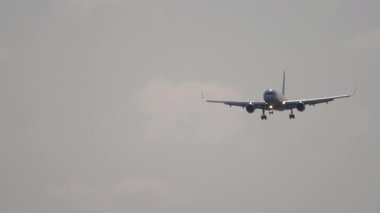 Uçak iniş yapıyor, ön manzara. Jet uçağı iniyor, iniyor. Mavi gökyüzünde bir uçak. Seyahat kavramı