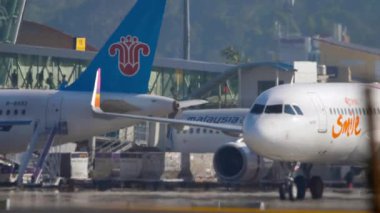 PHUKET, THAILAND - 12 Kasım 2019: Airbus A320, Thai Smile Airways 'den HS-TXH Phuket havaalanında taksicilik, yan görüş. Seyahat konsepti. Beneklenme