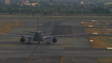 Tanımlanamayan bir jet uçağının taksi yolunda dikiz aynasından görüntüsü. Havaalanında ticari bir havayolu var. Beneklenme