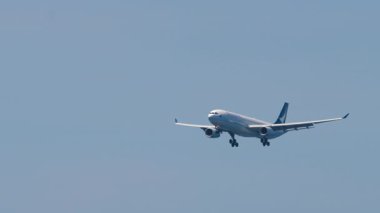 PHUKET, THAILAND - 19 Şubat 2023: Airbus A330 Cathay Pacific inişe yaklaşıyor. Gökyüzünde yolcu uçağı