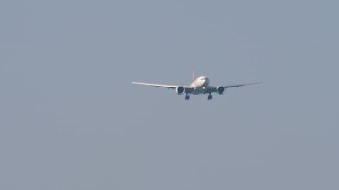 Yolcu uçağı gökyüzünde, ön manzara. İniş yapmadan önce yaklaşan bir uçak var. Seyahat konsepti. Beneklenme