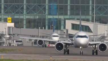 ALMATY, KAZAKHSTAN - 27 Haziran 2024: Airbus A321 Air Astana taksicilik. Astana Havayolları 'ndan Embraer E190. Almaty Uluslararası Havaalanı, Kazakistan 'a trafik