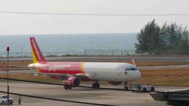 PHUKET, THAILAND - 07 Mart 2025: Phuket Havaalanı 'ndaki Tayland Vietnam Jet Havaalanı' ndan Airbus A321, HS-VKJ. Bir yolcu uçağını çekmek. Seyahat konsepti. Beneklenme