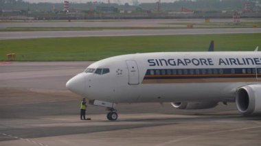 CHANGI, SINGAPORE - 30 HAZİRAN 2025: Boeing 737, Singapur Havayolları 'ndan 9V-MBI, Changi Havaalanı önlüğü, yan görüş. Uçak kalkışa hazır.