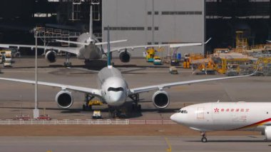 HONG KONG - 28 HAZİRAN 2025: hangarda ve havaalanında uçaklar. Airbus A330, Hong Kong Hava Taşımacılığı B-LNY Chek Kap Kok Havalimanı, Hong Kong, yan görüş