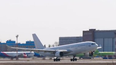 NOVOSIBIRSK, Rusya Federasyonu - 27 Nisan 2024: Ticari jet uçağı Airbus A330, RA-73688 I-Fly kalkış, yan görüş. Uçak kalkıyor. Beneklenme