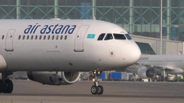 ALMATY, KAZAKHSTAN - 27 Haziran 2024: Airbus A321, Almaty Havaalanı 'nda Astana Havayolları' ndan EI-KDA. Uçak havalanıyor. Önlük, havaalanı terminali
