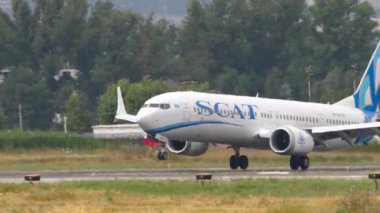 ALMATY, KAZAKHSTAN - 24 Haziran 2024: SCAT Airlines Boeing 737, Almaty havaalanındaki piste iniyor. Jet yavaşlıyor, spoiler veriliyor. Uçak geliyor.