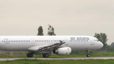 ALMATY, KAZAKHSTAN - 11 Mayıs 2024: Airbus A321, Air Astana havaalanında taksicilik yapan EI-KDA. Havaalanında yolcu uçağı var. Seyahat konsepti. Beneklenme