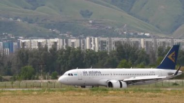 ALMATY, KAZAKHSTAN - 24 Haziran 2024: Almaty havaalanına indikten sonra Astana Hava Yolları yavaşlıyor. Uçak geliyor. Spoiler verin. Seyahat kavramı