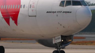 PHUKET, THAILAND - 14 Şubat 2025: Aircraft Boeing 777, RA-73329 Red Wings taksisi, yakın çekim. Uçak şasisi ve motor. Seyahat kavramı