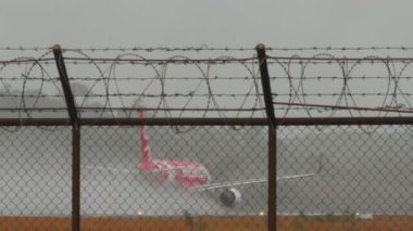 PHUKET, THAILAND - 24 Şubat 2025: Lowcost AirAsia Airbus A320, HS-CBA hızlandı ve Phuket havaalanında yağmurda havalandı. Uçak motorlarının gücüyle havaya su püskürtüldü.