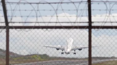 Havalanan bir uçağın yavaş çekim görüntüleri, havaalanı çitlerinden manzaralı. Havacılık, uçuş, seyahat konuları