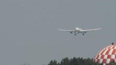 Yolcu uçağı inişe geçiyor. Uçak geliyor. Hava sahasında sis, sıcak bir gün. Seyahat kavramı