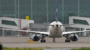 Arka görüş, terminale giden bir uçak. Uçak varmak üzere. Bir arabayı takip eden bir uçak..