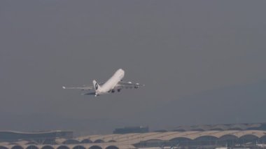 Kalkıştan sonra yükselen geniş gövdeli bir jetin uzaktan görüşü. Hava taşımacılığı, küresel ulaşım ve ticari havacılık kavramları için ideal