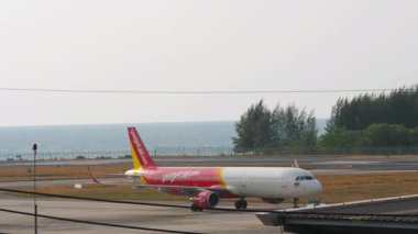 PHUKET, THAILAND - 07 Mart 2025: Phuket Havaalanı 'nda Tayland Vietnam Jet Havaalanı' ndan Airbus A321, HS-VKJ 'yi iten Tug. Seyahat konsepti. Beneklenme