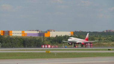 MOSCOW, Rusya Federasyonu - 31 Temmuz 2021: Sukhoi Superjet 100, RA-89110 Rossiya iniş pisti, yan görüş. Yolcu uçağı geliyor. Spoiler hazır.