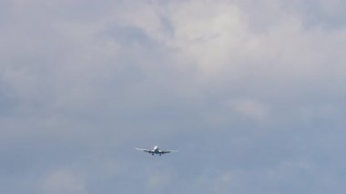 Tanımlanamayan bir üniformayla iniş yapan ticari bir jetin uzak görüntüsü.