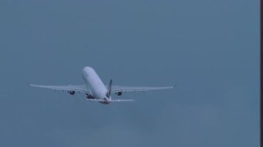 KUALA LUMPUR, MALAYSIA - 14 HAZİRAN 2025: uzak çekim, Airbus A330, B-LBK Cathay Pacific pistinden yağmur altında kalkıyor. Gökyüzünde uçak, dikiz manzarası