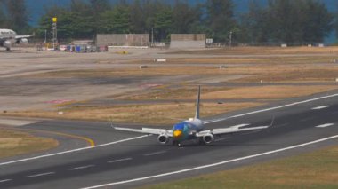 PHUKET, THAILAND - 12 Mart 2025: Boeing 737, Nok Air 'den HS-DBP indikten sonra fren yapıyor. Uçak pistte, yan görüş. Uçak geliyor. Seyahat kavramı