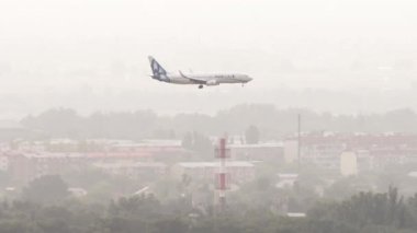 ALMATY, KAZAKHSTAN - 26 Haziran 2024: Uçak Boeing 737, UP-B3735 Almaty havaalanına SCAT inişi, yan görüş, uzak çekim. Seyahat konsepti. Trafik vardı.