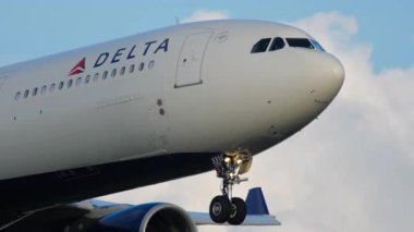 AMSTERDAM, NETHERLANDS - 25 Temmuz 2017: günbatımında Delta Air Airbus A330 'un vurulması. Havayolu, ulaşım ve ticari projeler için mükemmel seyahat ve havacılık görüntüleri