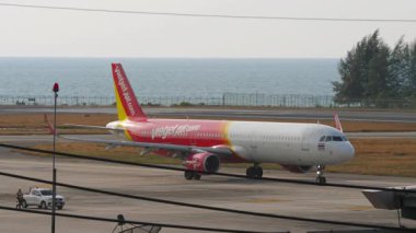 PHUKET, THAILAND - 07 Mart 2025: Phuket Havaalanı 'ndaki Vietnam Jet Air Airbus A321 yolcu uçağı. Seyahat konsepti. Havaalanı ve deniz arka planı