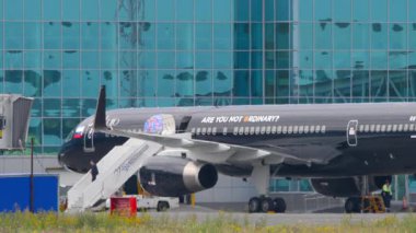 NOVOSIBIRSK, RUSSIAN FEDERASYONU - 15 Temmuz 2022: Lujo Art Joy Livery Boeing 757, RA-73029 Tolmachevo havaalanı terminalinde. Uçağa biniş rampası
