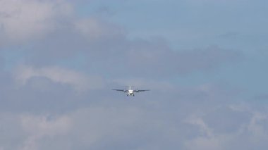 Tanımlanamayan bir üniformanın iniş yaptığı ticari bir turbo pervane uçağı görüntüsü. Gökyüzünde bir uçak. Seyahat kavramı