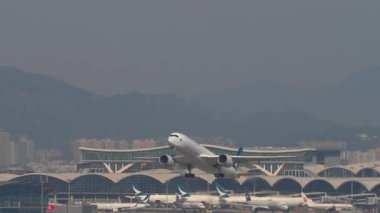 HONG KONG - 29 Ocak 2025: Cathay Pacific Airbus A350-941, B-LRS kalkış ve tırmanma, iniş takımları geri çekildi. Uçak uçuyor. Seyahat kavramı