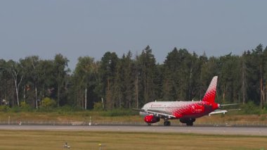 MOSCOW, Rusya Federasyonu - 31 Temmuz 2021: Sukhoi Superjet 100, RA-89114 Rossiya indikten sonra fren yapıyor. Uçak pistte, yan görüş. Seyahat kavramı