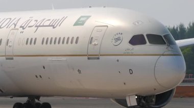 PHUKET, THAILAND - 14 Şubat 2025: Orta atış, yolcu uçağı Boeing 787 Dreamliner, Saudia taksicilik HZ-ARD, yan görüş, orta çekim. Seyahat kavramı