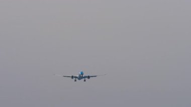 Çizgili üniformalı jet yolcu uçağı iniş yapmak üzere, uzun menzilli, ön görüş. Seyahat kavramı