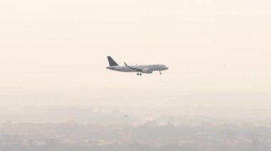 ALMATY, KAZAKHSTAN - 26 Haziran 2024: Airbus A320 Air Astana Almaty şehrine iniyor. Uçak uçuşu, yan görüş, uzak çekim.