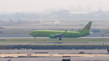BANGKOK, THAILAND - 01 Mart 2023: Airplane Boeing 737, RA-73668 S7 Airlines, Suvarnabhumi havaalanına iniş ve frenleme. Uçak geliyor. Beneklenme