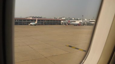 BANGKOK, THAILAND - 31 HAZİRAN 2025 Apron, pencereden görüş. Tayland Lion Air uçağı Don Mueang Havaalanı 'nın önlüğüne park etmiş. Seyahat, havacılık.